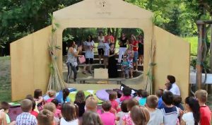 Bambini in ascolto delle storie raccontate dai narratori posti dietro ad un teatrino kamishibai